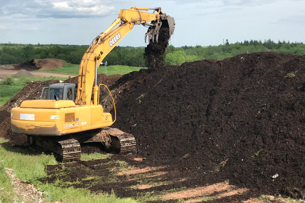 Digger turning WIndrows at Compost Supplier in Colchester County